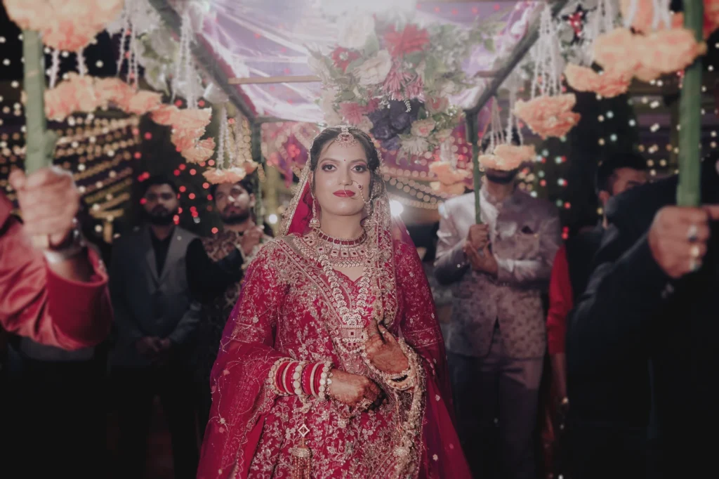 A bride arrives beneath a floral canopy