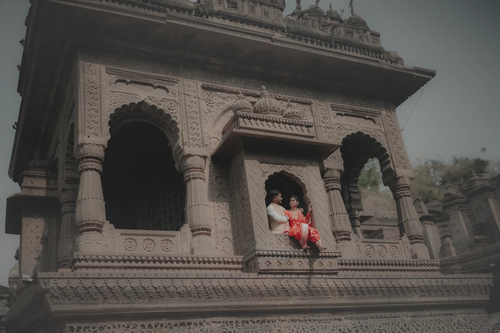 A couple framed by stone architecture
